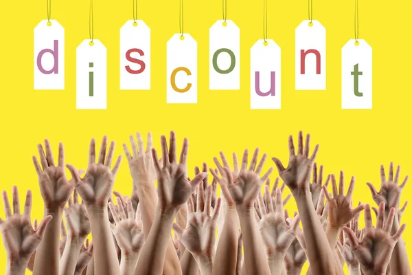 Discount word on labels over yellow gradient background, people's hands lifted up in the air.. Sale poster. Festive backdrop poster on Black Friday theme with copy space and clipping pass