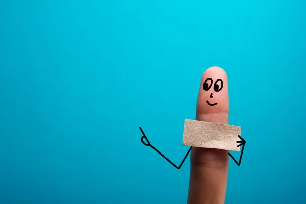 Dedo engraçado segurando bunner em branco mostrando nele e sorrindo — Fotografia de Stock