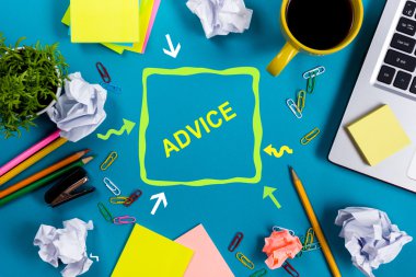 Tavsiye motivasyon. Ofis tablo büro malzemeleri, beyaz boş not defteri, Kupası, kalem, pc, buruşuk kağıt, ahşap arka plan üzerinde çiçek. Üstten Görünüm
