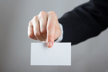 Holding bir beyaz kartvizit ziyaret, Hediyelik, Bilet, eller geçmek, yakın kadar üzerinde mavi arka plan bulanık mevcut. Kopya alanı