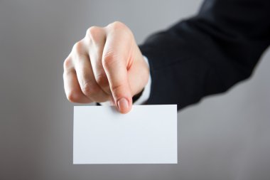 Holding bir beyaz kartvizit ziyaret, Hediyelik, Bilet, eller geçmek, yakın kadar üzerinde mavi arka plan bulanık mevcut. Kopya alanı