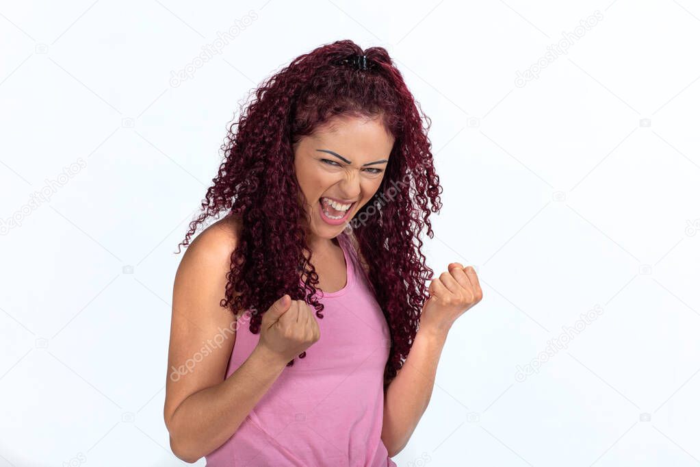 Portrait of a happy woman vibrating successfully, clenched fists and punching the air with joy. Isolated on a white background.