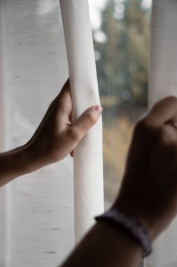 Eller görmek için bir pencere perdesi açıyor