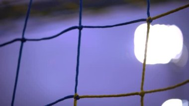 Sarı futbol kalesini kapat mor gökyüzüne ve ışık kulesine karşı sallan