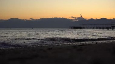 Gün batımında ya da gündoğumunda sahilin üzerine dökülen dalgaya odaklan