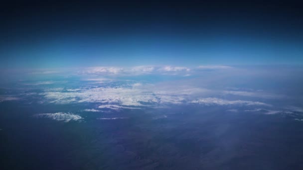 Bulutlu mavi gökyüzü ve karla kaplı dağları uçak penceresinden izle — Stok video