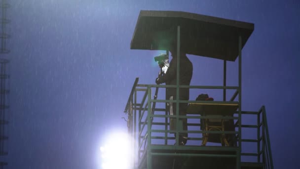 Déšť stadion oblačná obloha, muž s kamerou na věži je natáčení sportovní soutěže — Stock video