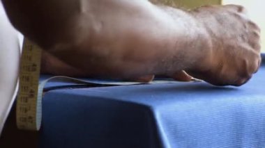 Tailor marking the fabric cloth with a chock piece.