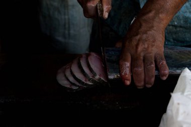 Hindistan, Mangalore 'da Kral uskumru balığını dilimleyen insan eli.