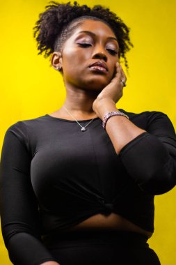 Yüzünde doğal saçlar olan siyahi bir kadının portresi, tamamen siyah giyinen siyah bir kadın, gözleri kapalı bir kadın, doğal saçlı bir kadın.