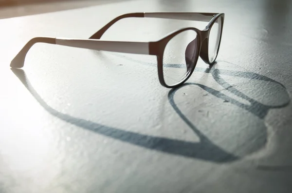 Óculos de olho com luz solar e sombra refletem no chão áspero — Fotografia de Stock