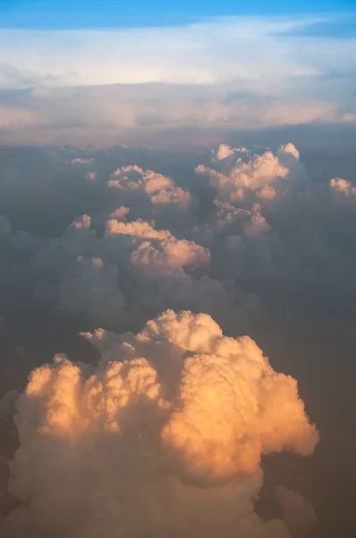 Облака и восход солнца через окно на самолете — стоковое фото