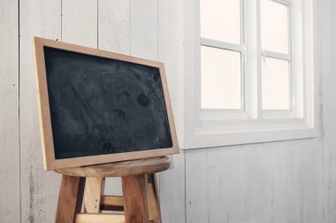 Ön plan kirli kara tahta bir beyaz yakınındaki yuvarlak ahşap sandalye