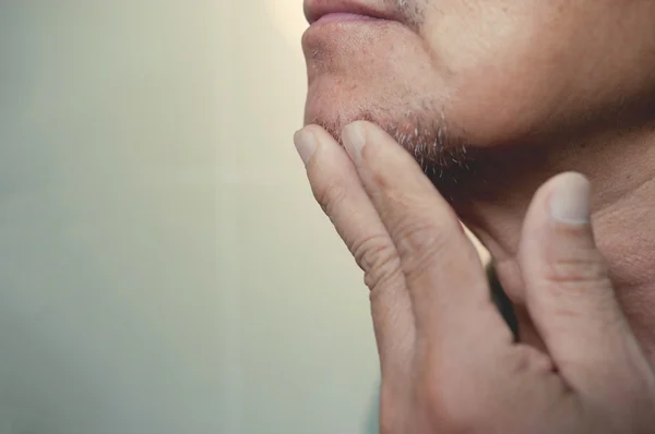 stock image  Asian old man is shaving his beard