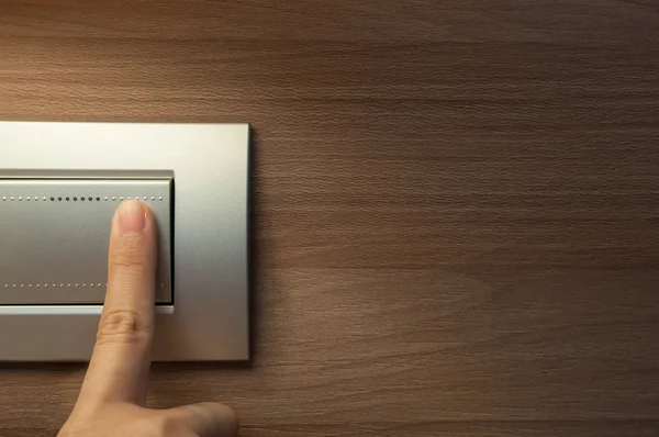 Finger is turning on a grey light switch. — Stock Photo, Image
