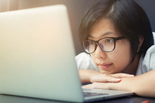 Menina asiática sorrindo e olhando para seu laptop . — Fotografia de Stock