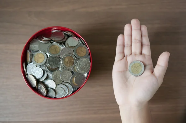 Peníze v červený kbelík, Kid ruka držící peníze mince — Stock fotografie