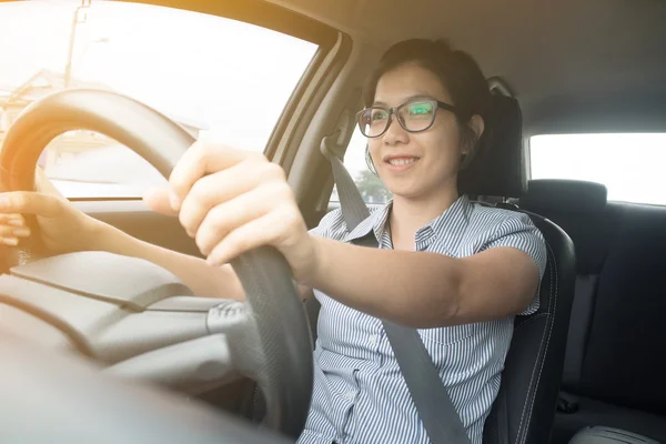 Asiatiska glasögon kvinna ler och köra bil. — Stockfoto