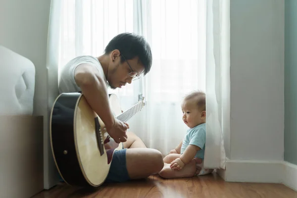 Pai Asiático Sentado Chão Madeira Tocando Guitarra Acústica Com Seu — Fotografia de Stock