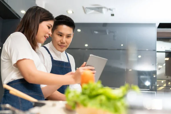 아시아인젊은 가집에 현대식 주방에서 요리하면서 디지탈 태블릿을 사용하는 — 스톡 사진