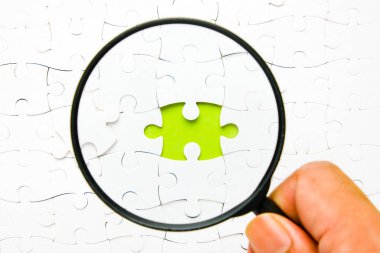 Kopyalama alanı yeşil arkaplan ve büyüteç görüşlü bir yapboz resmi