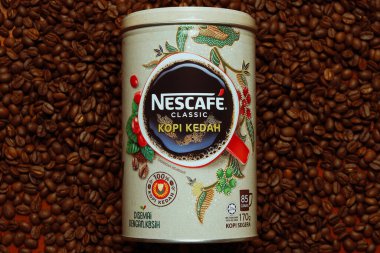 Kahve çekirdeğinin üzerindeki Nescafe Classic Kopi Kedah kutusunun klasik resmi. Bu sürüm Kedah 'daki yerel kahve endüstrisini artırmaya yardımcı oluyor..