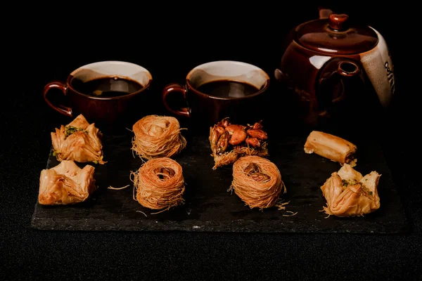 Arap baklavasının sade ve seçici bir fotoğrafı, arap kahve anlayışına sahip levha üzerinde..