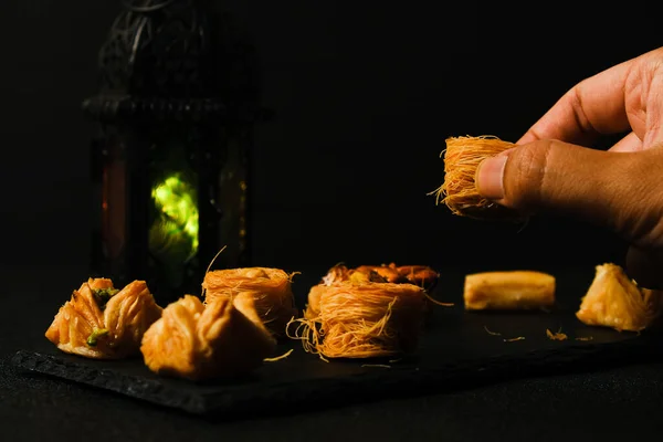 Seçici odak ve el resmi, fener görüşlü levha üzerinde Arapça Baklava çekiyor.. 
