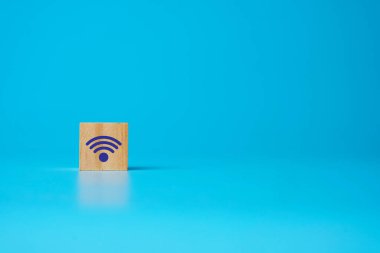 Mavi telif alanı arka planındaki tahta bloktaki WIFI sinyalinin resmi.