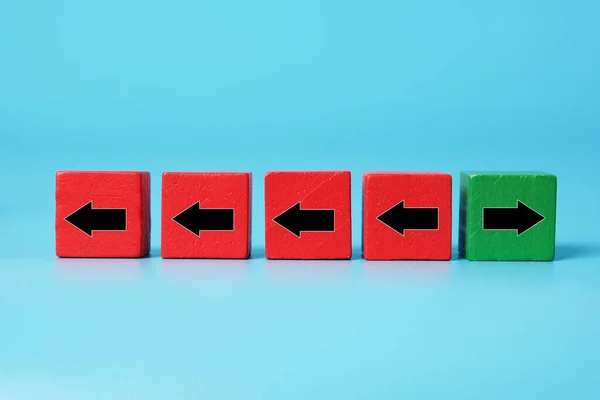 A picture of 4 red cube  to the left. 1 green cube to the right. Think out of the box, differently and brave making decision.
