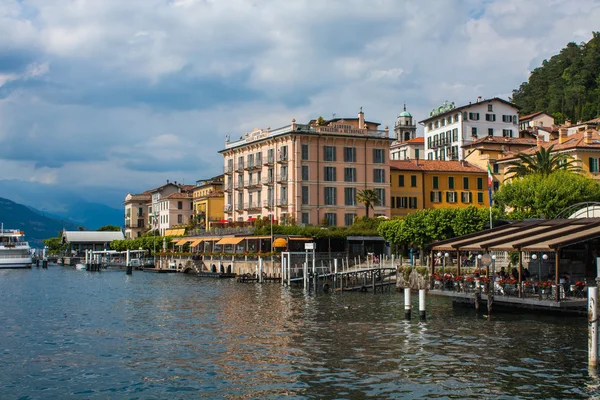 BELLAGIO SOBRE LAGO COMO, ITALIA, 15 DE JUNIO DE 2016. Vista de la costa de la ciudad de Bellagio en el Lago de Como, Italia. Paisaje italiano ciudad con hoteles, edificios en la orilla y muelles de taxi acuático ferry — Foto de Stock