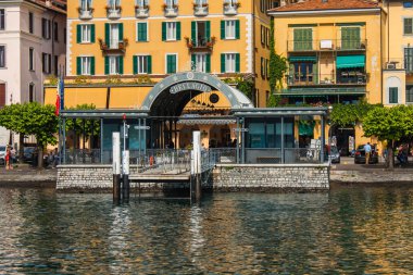 BELLAGIO ON LAKE COMO, ITALY, JUNE 15, 2016. View on coast line of Bellagio city on Lake Como, Italy. Italian landscape city with hotels, buildings on the shore and ferry water taxi docks clipart