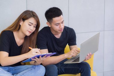 Asyalı genç çift, takım çalışması olarak çalışan ve iş için çeşitli teknolojiler kullanan yeni bir e-ticaret girişimcisi. İş ve e-ticaret kavramı