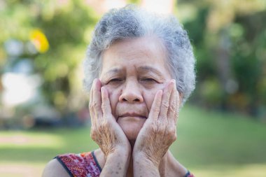 Bahçede dikilirken son sınıf dişleri ağrıyor. Yaşlılar ve sağlık hizmetleri kavramı.