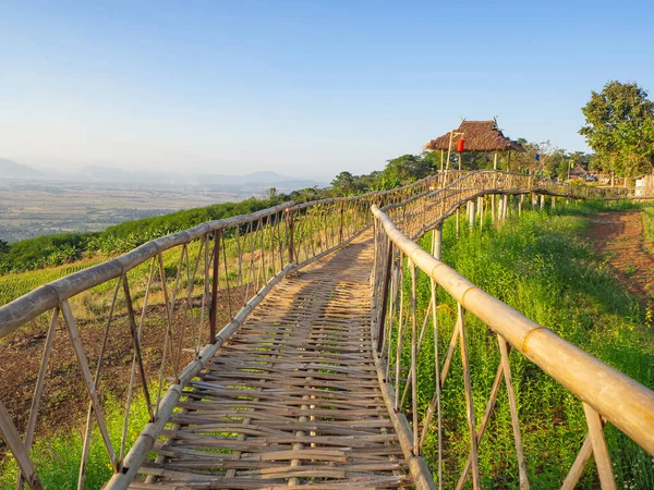 Dağların arka planına sahip bambu köprüsünün manzara manzarası.
