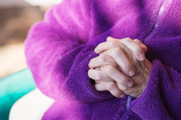 Крупный План Рук Пожилой Женщины Молящейся Сидя Дома Стуле — стоковое фото