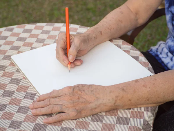 Κοντινό Πλάνο Της Ηλικιωμένης Γυναίκας Που Γράφει Ένα Βιβλίο Στο — Φωτογραφία Αρχείου