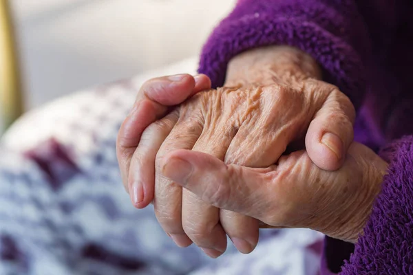 Close-up of wrinkly hands of an elderly woman. Concept of aged people and healthcare.