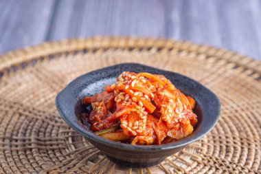 Geleneksel Koreli (Kimchi) porselen paspasın üzerinde bir kase içinde. Mesaj için yer var. Kore yemekleri kavramı..