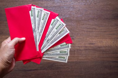 Çin Yeni Yılı 'nda çocuklara kutsanması için içinde dolar (veya Ang Pao) olan kırmızı bir zarf paketini yakın plan çekimde hazır bulundurun. Mesaj için yer var. Festival konsepti.