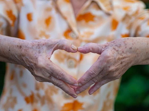 老太婆站在花园时 用手拍了一个心形符号 文字空间 老年人和保健的概念 — 图库照片