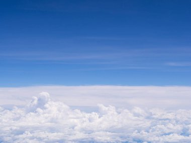 Uçak penceresinden görülen bulutlu hava manzarası.