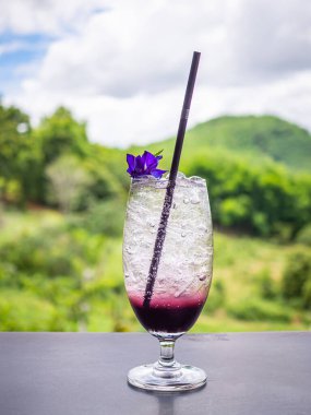 Bir bardak buzlu çilekli gazoz, ahşap bir masanın üzerinde, çok güzel bir arka planı var. İçecekler ve rahatlama kavramı.