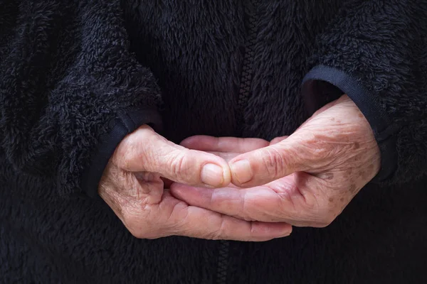 Close-up of wrinkled hands senior woman joined together for meditation. Concept of aged people and religion.