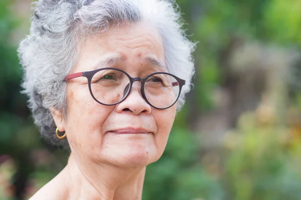 Retrato Una Anciana Con Gafas Mirando Hacia Otro Lado Mientras — Foto de Stock