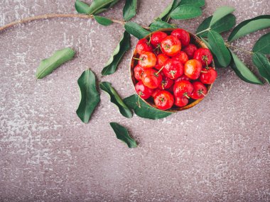 Taş zeminde yaprakları olan seramik bir kasede olgun kırmızı kirazların üst görüntüsü. Mesaj için yer var. Tatlı organik meyveler. Sağlıklı meyve kavramı