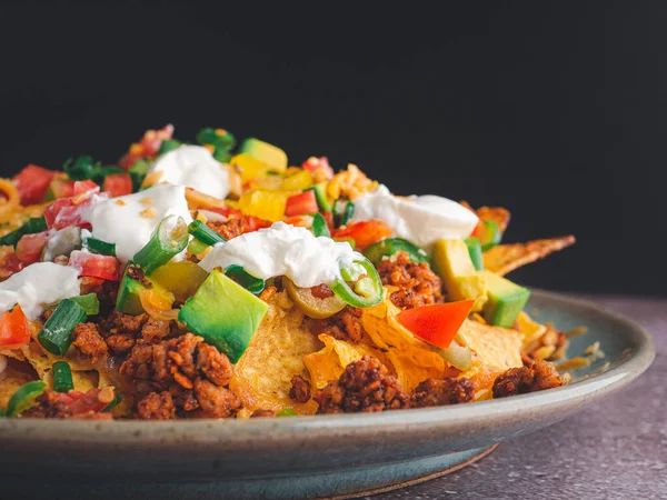 Seitenansicht Von Beladenen Hackfleisch Nachos Auf Teller Mit Schwarzem Hintergrund — Stockfoto