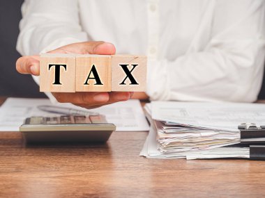 Tahta küplerin el ele tutuşması. Vergi formları ve hesaplamalarında yardım. Vergi günü konsepti. Yakın plan fotoğraf.