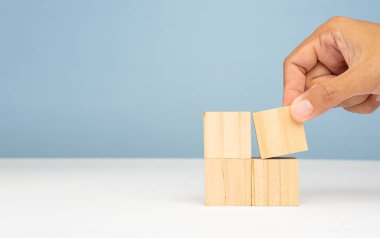 Açık mavi zeminli mermer bir masada dört tahta küp. Metin için boşluk