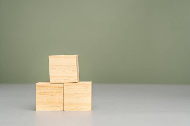 Yeşil arka planı olan üç boş tahta küp. Metin için boşluk